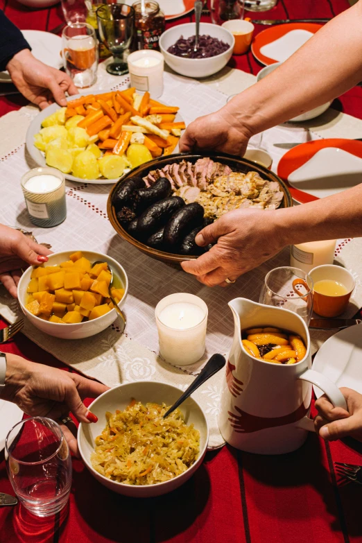 a group of people sitting around a dinner table, bowl filled with food, polish food, holiday season, hands