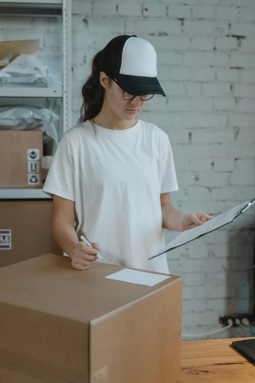 a woman holding a clipboard in front of a box, pexels contest winner, white hat, australia, gif, inventory item