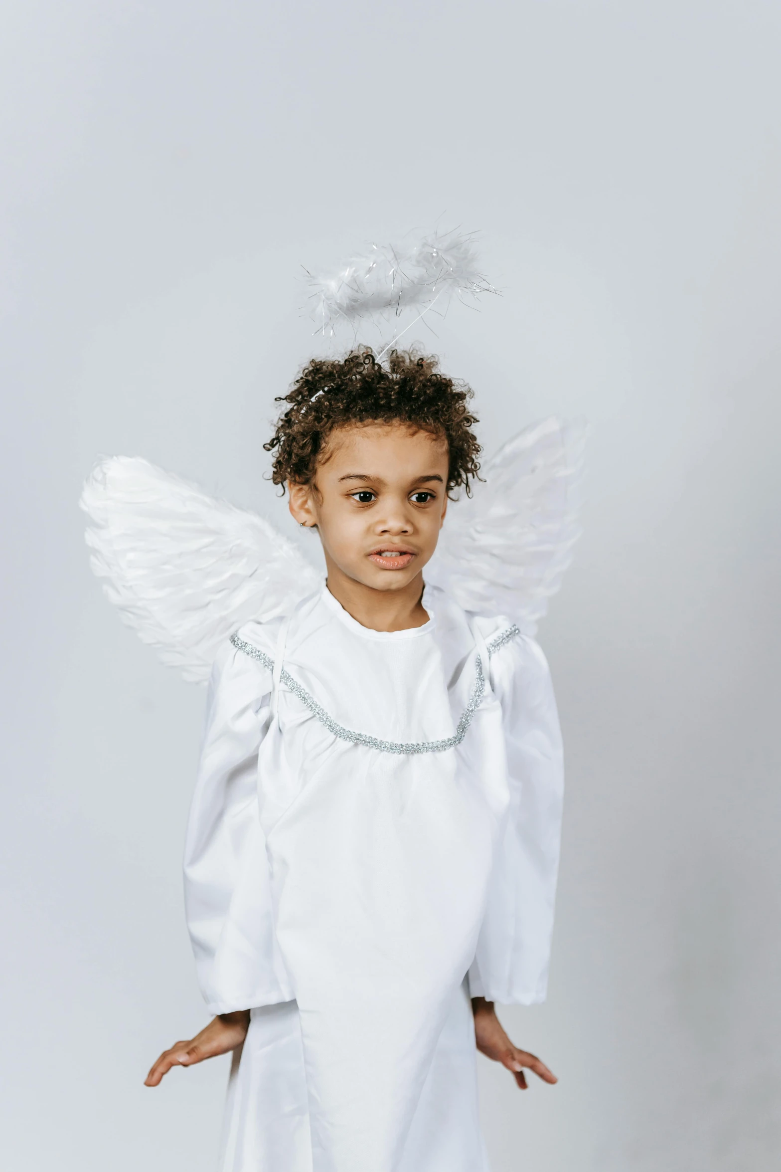 a little girl dressed up as an angel, an album cover, pexels contest winner, renaissance, plain background, young boy, diverse costumes, high resolution product photo