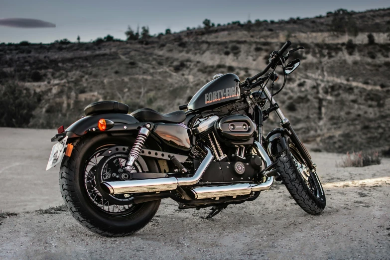 a black motorcycle parked on a dirt road, pexels contest winner, photorealism, harley queen, side profile view, titanium, asphalt and metal