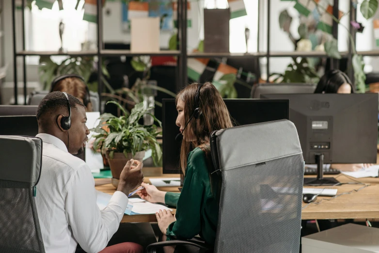 a couple of people sitting at a table with computers, pexels contest winner, hurufiyya, in an call centre office, avatar image, lachlan bailey, wearing headset