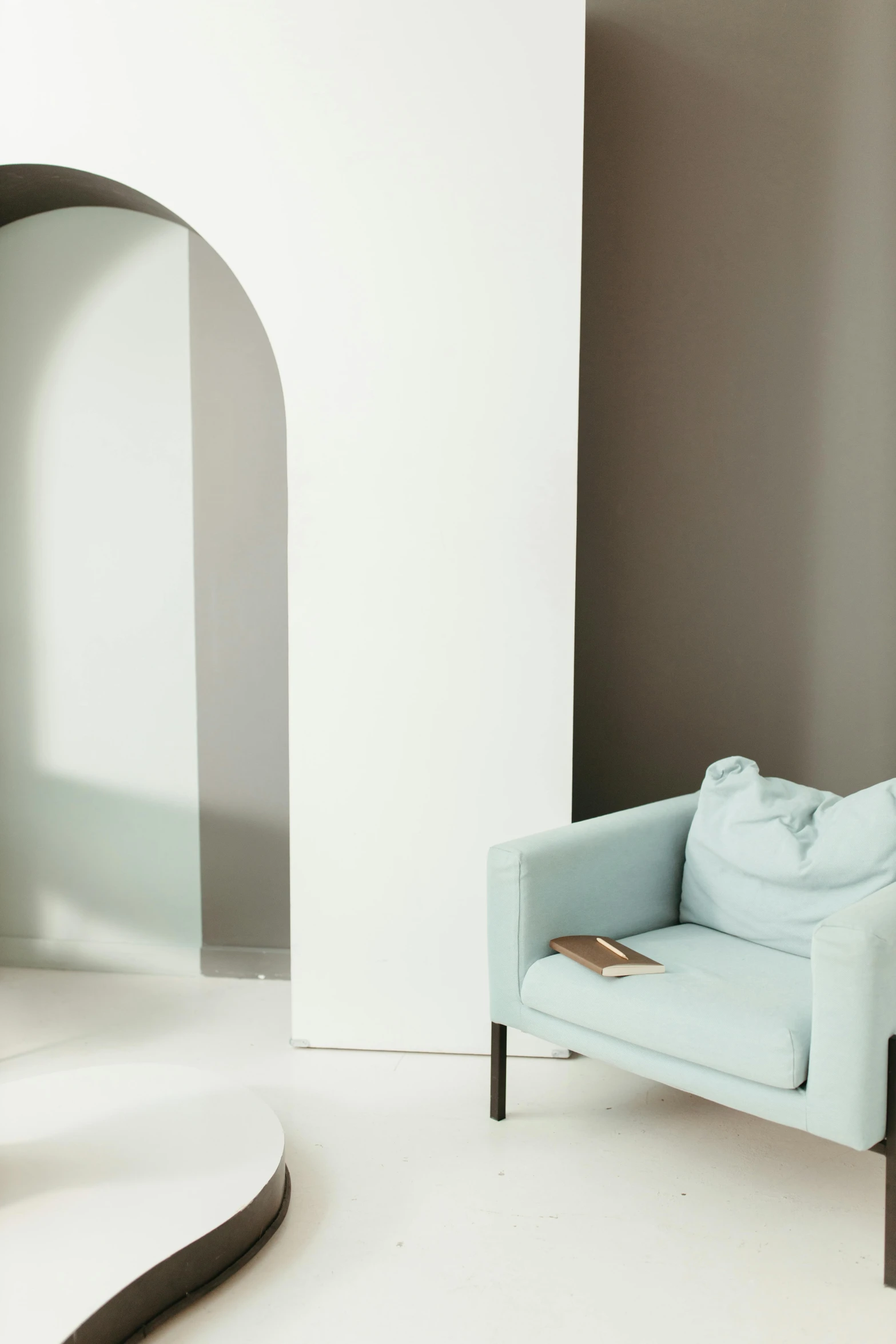 a blue chair sitting on top of a white floor, light and space, an archway, seafoam green, official store photo, muted colors. ue 5