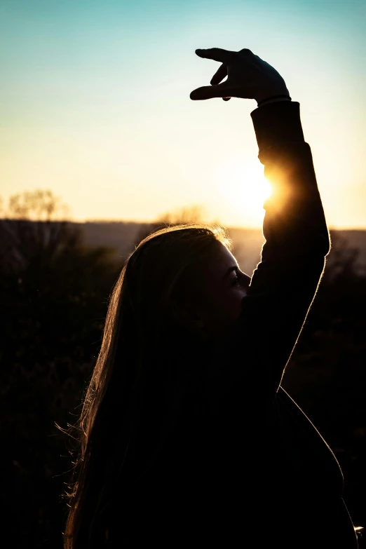 a woman that is standing up with her hands in the air, by Jeffrey Smith, pexels, sun shaft, taking a selfie, dabbing, rectangle