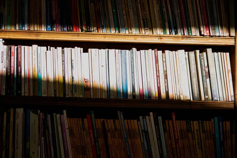 a book shelf filled with lots of books, an album cover, pexels, shafts of sunlight in the centre, thumbnail, shadows, bottom angle