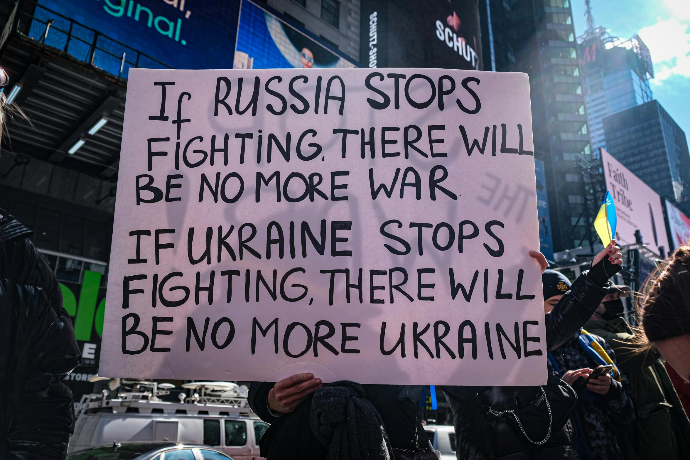 a person holding a sign that says it russian stops fighting there will be no more war it ukraine stops fighting there will be no more ukraine, reddit, times square, thumbnail, taken in the early 2020s, square