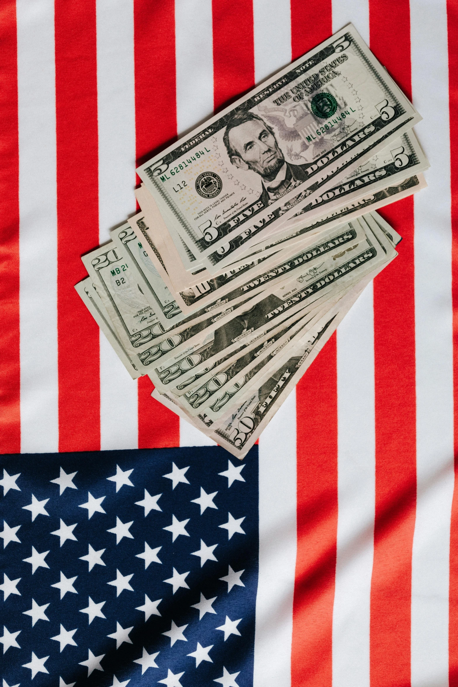 a pile of money sitting on top of an american flag, a portrait, shutterstock, instagram post, flags, conservative, coast