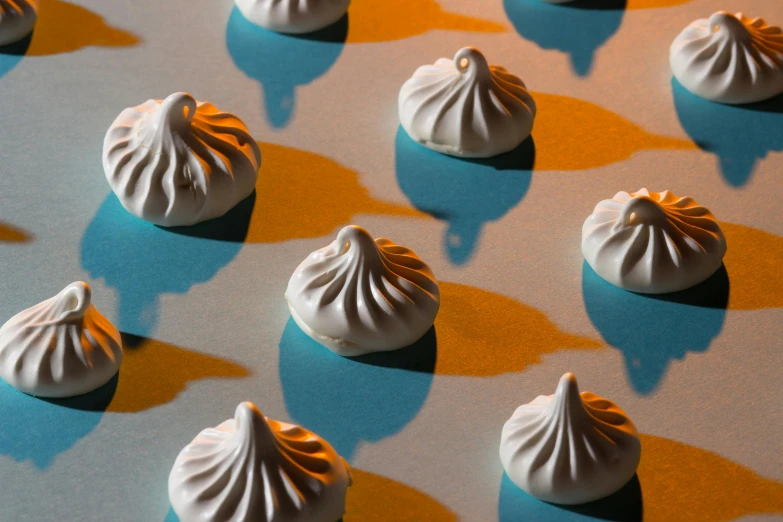 a group of meringue sitting on top of a table, with ominous shadows, reaction diffusion, domes, whitehorns