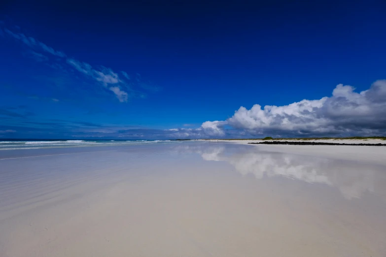 a large body of water sitting on top of a sandy beach, white sand, lariennechan, the infinite, big sky