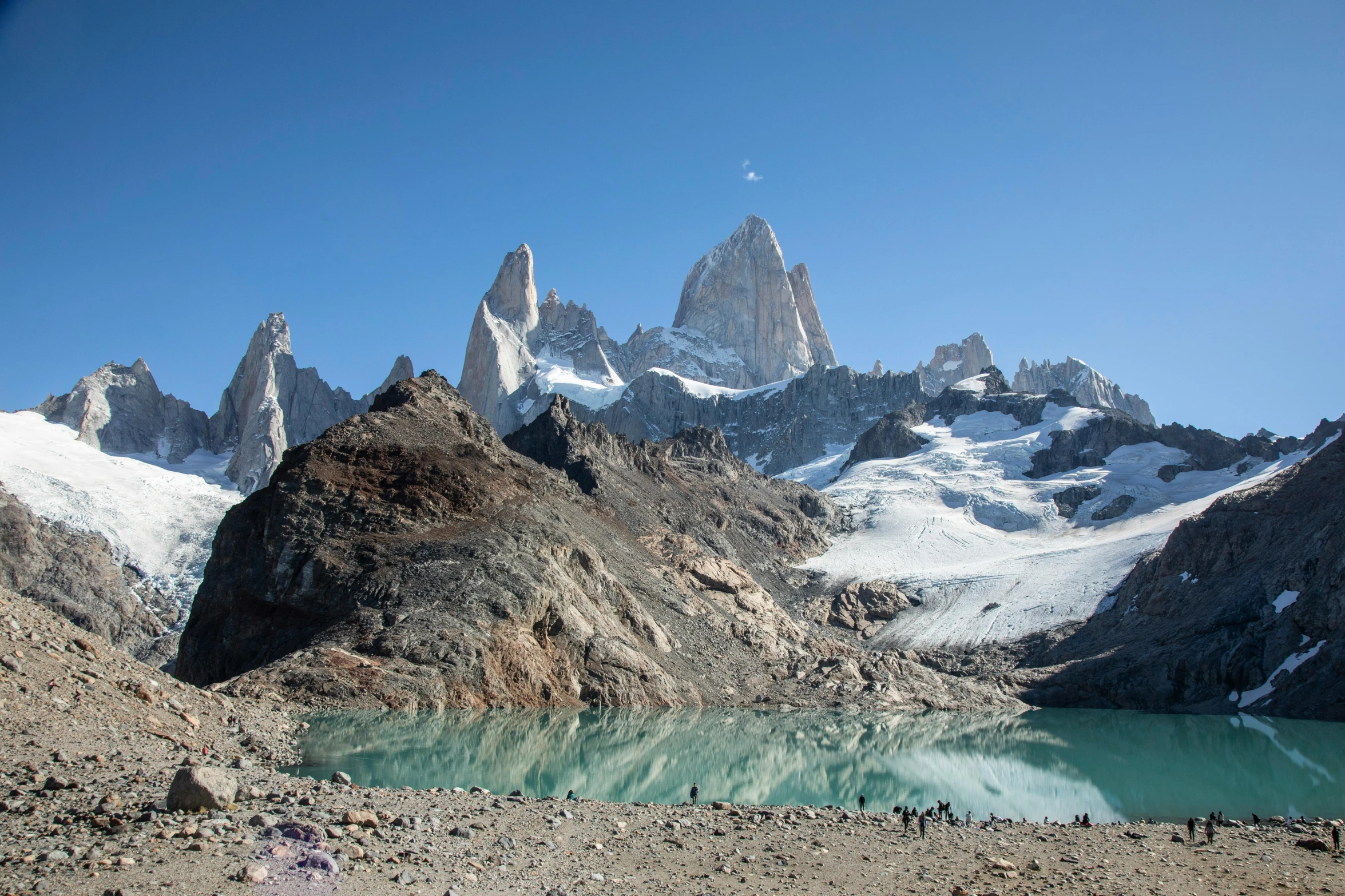 a group of people standing on top of a mountain next to a body of water, inspired by Alejandro Burdisio, pexels contest winner, asymmetrical spires, patagonian, polarizer filter : 1 0, polar