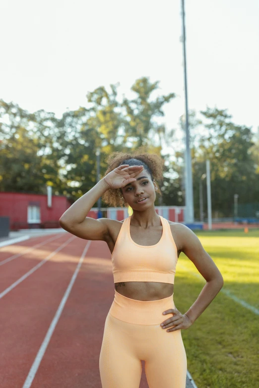 a woman standing on a track with her hands on her head, sports bra, medium skin tone, 5 0 0 px models, university