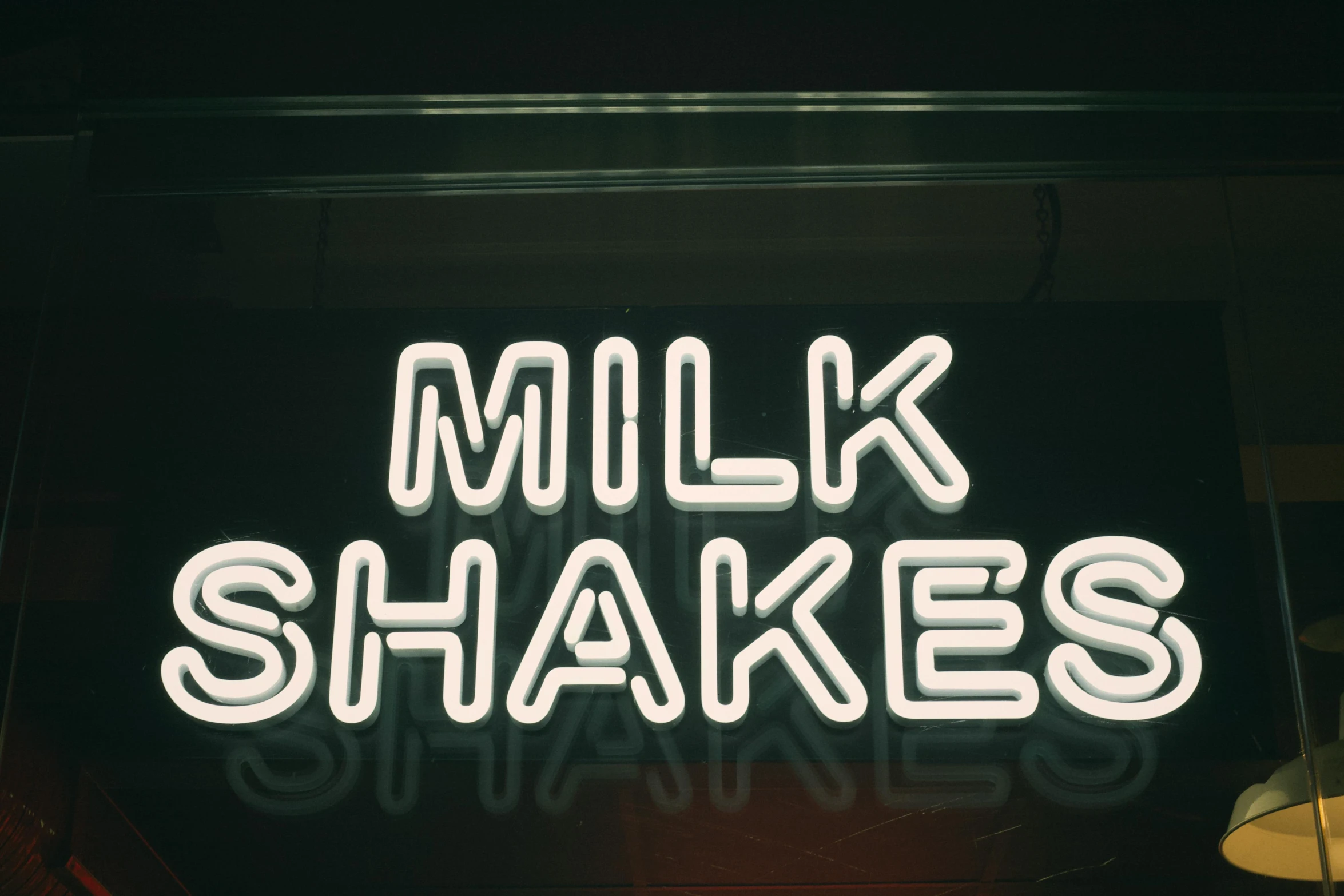 a neon sign that says milk shakes, inspired by Elsa Bleda, trending on unsplash, broken shackles, high quality photo, alessio albi, 1970s photo