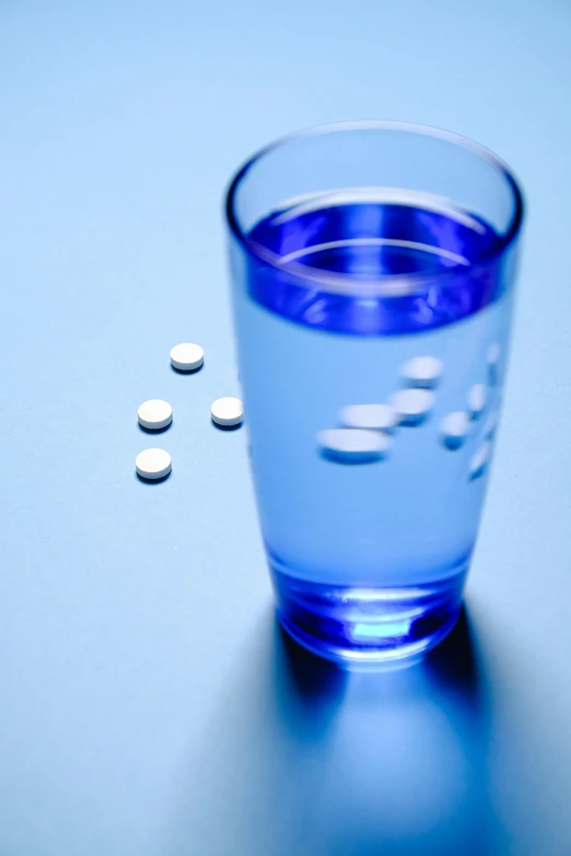 a glass of water with pills coming out of it, a digital rendering, by Dan Luvisi, pexels, blue reflective eyes, a long-shot, a tall, contracept