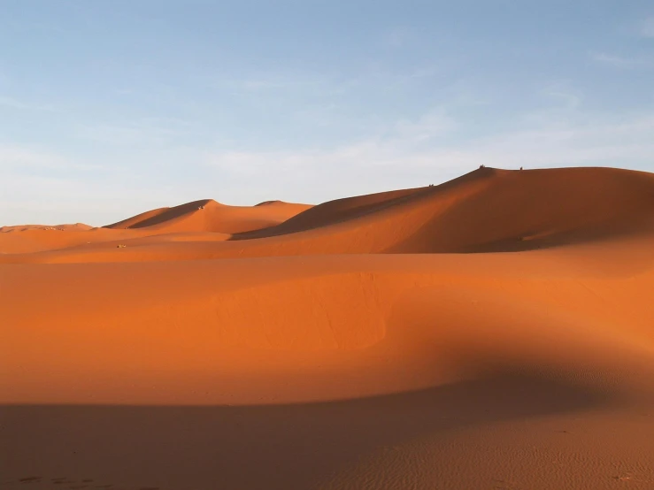 a group of people walking across a desert, pexels contest winner, hurufiyya, vibrant orange, victorian arcs of sand, early evening, sand banks