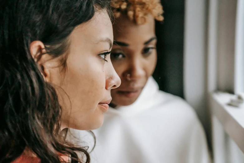 a close up of two women looking out a window, trending on pexels, mixed race, realistic »