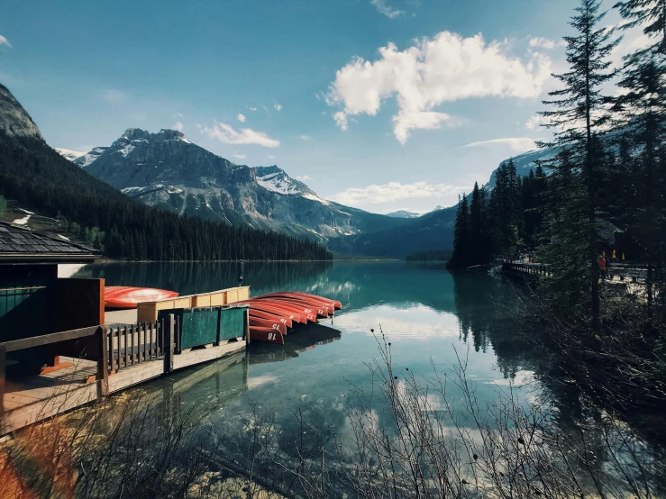 a group of boats sitting on top of a lake, by Jessie Algie, pexels contest winner, hurufiyya, banff national park, small dock, crystal clear blue water, alessio albi