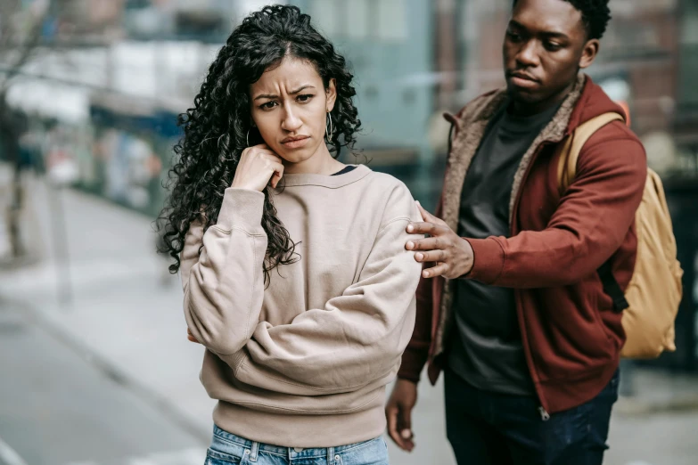 a man standing next to a woman on a city street, trending on pexels, renaissance, with a hurt expression, brown clothes, teenage girl, woman holding another woman