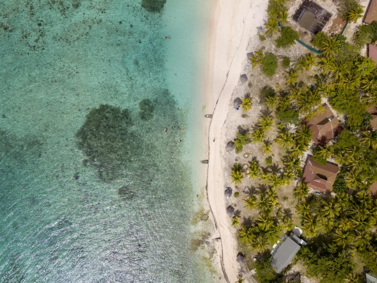 an aerial view of a beach in the middle of the ocean, a screenshot, pexels contest winner, huts, samoan features, thumbnail, bottom angle