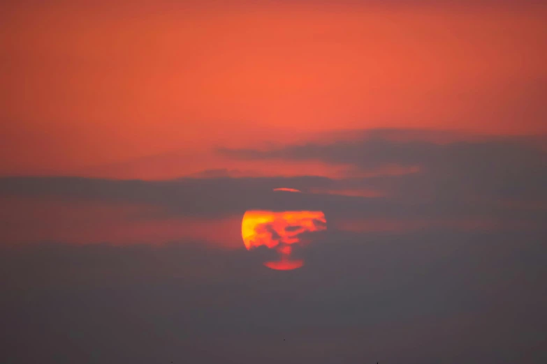 the sun is setting behind the clouds in the sky, by Attila Meszlenyi, orange halo, pareidolia, glowing red, uncropped