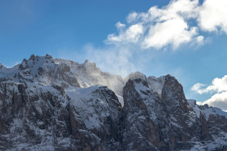 a group of people riding skis down a snow covered slope, an album cover, by Carlo Martini, pexels contest winner, romanticism, rocky cliffs, covered in clouds, avatar image, dolomites