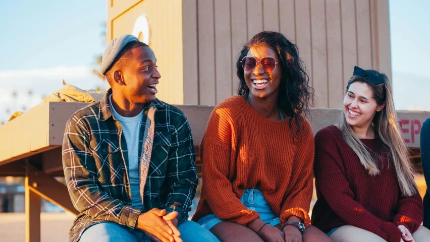 a group of people sitting next to each other on a bench, a portrait, trending on pexels, brown skin man with a giant grin, girl sitting on a rooftop, teal and orange colours, teenage girl