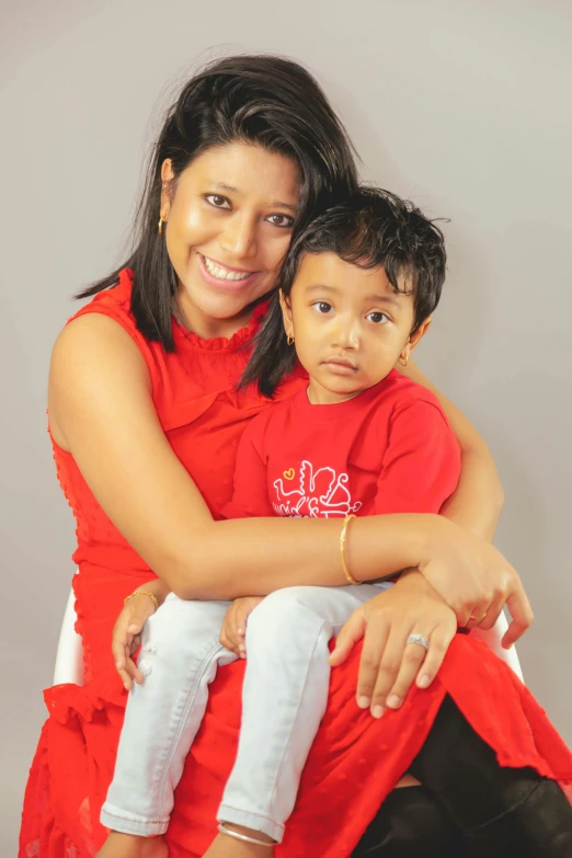 a woman and a child posing for a picture, wearing a red outfit, jayison devadas, portrait image, compressed jpeg