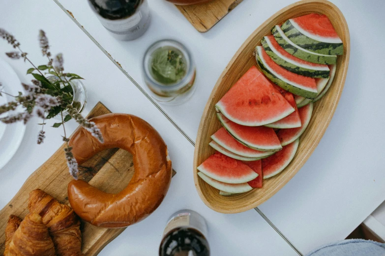 a table that has a bunch of food on it, pexels contest winner, watermelon, bagels, dad bod, subtle details