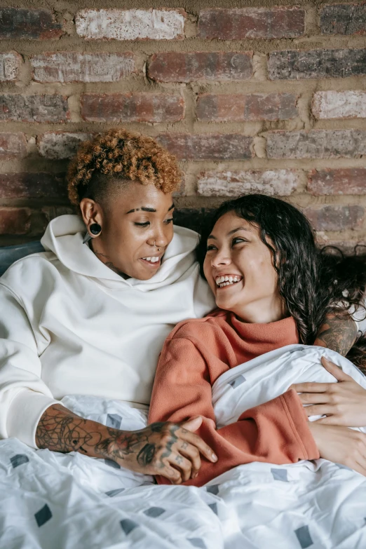 a man and woman laying in bed next to each other, trending on pexels, happening, lesbian embrace, mixed race, tattooed, ashteroth