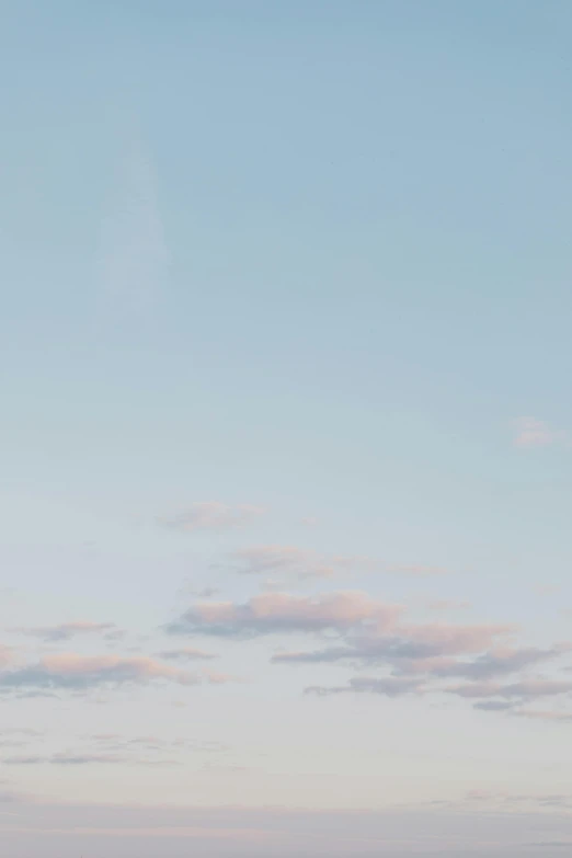 a man flying a kite on top of a sandy beach, unsplash, postminimalism, light pink clouds, cinematic shot ar 9:16 -n 6 -g, peaceful puffy clouds, nordic pastel colors