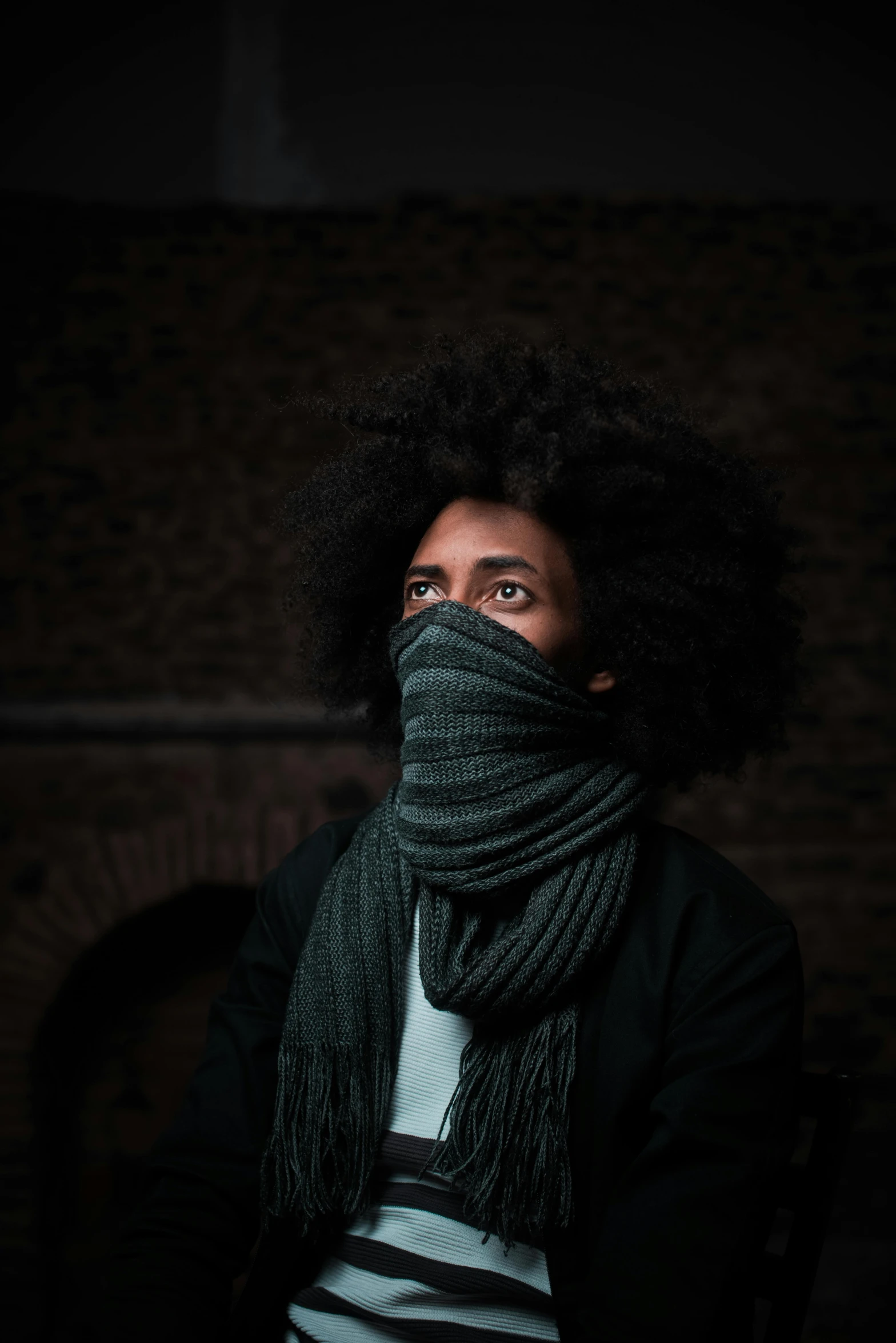 a woman with a scarf wrapped around her face, inspired by Gordon Parks, pexels contest winner, afrofuturism, black man with afro hair, wearing bandit mask, chilly dark mood, taken in the late 2010s