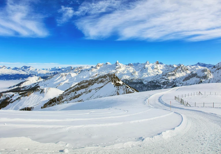 a person riding skis down a snow covered slope, the panorama, elaborate, dolomites in the background, big sky