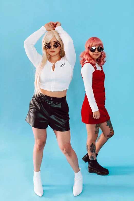 two women standing next to each other on a blue background, an album cover, inspired by Wang Duo, trending on pexels, international gothic, wearing red shorts, tifa lockhart with white hair, cosplay photo, overalls