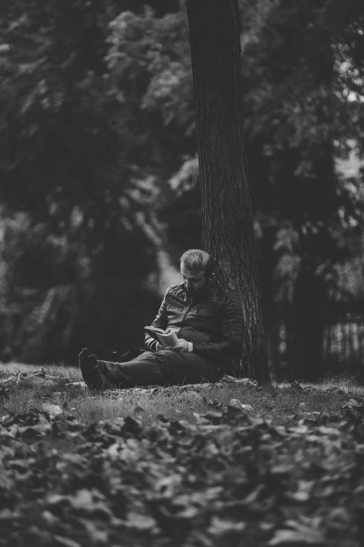 a black and white photo of a person sitting under a tree, by Adam Marczyński, pexels contest winner, old man doing with mask, reading the book about love, 15081959 21121991 01012000 4k, sittin