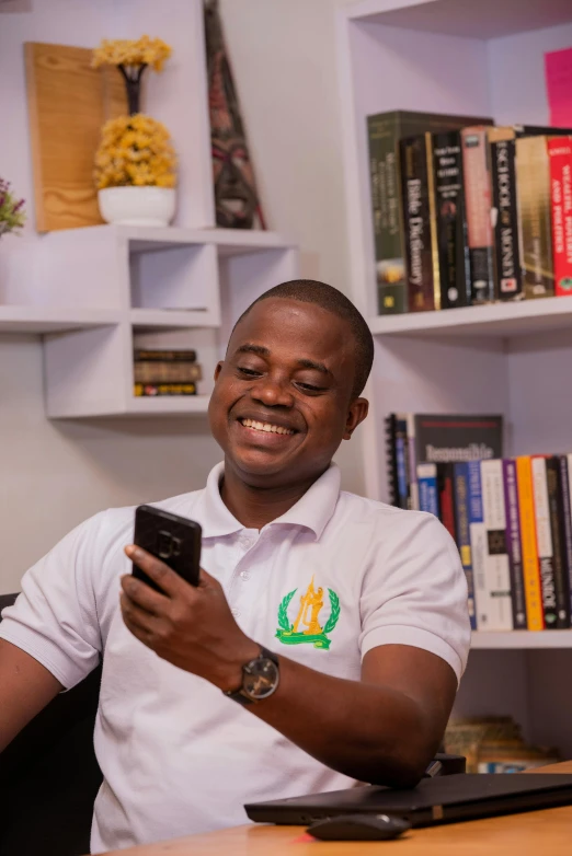 a man sitting at a desk using a cell phone, by Chinwe Chukwuogo-Roy, pexels contest winner, giddy smirk, librarian, casually dressed, at home