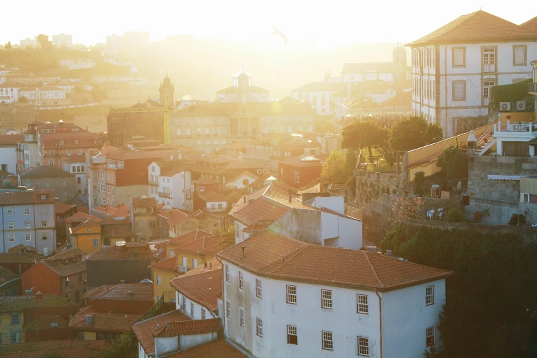 a view of a city from the top of a hill, inspired by Almada Negreiros, pexels contest winner, happening, bright dappled golden sunlight, light breaks through the roofs, white, 2 5 mm portra