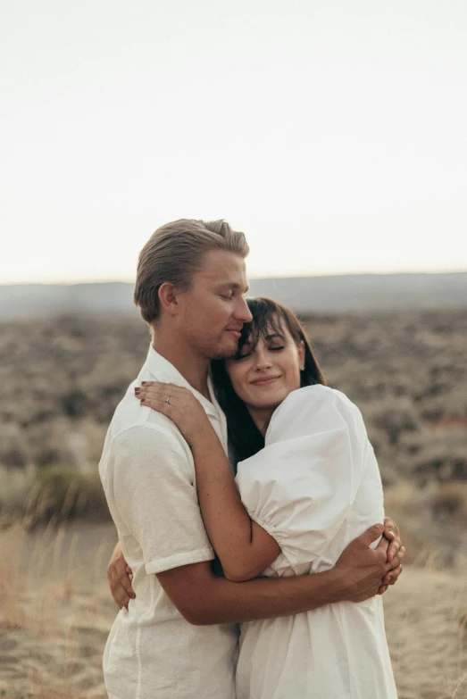 a man and a woman hugging in the desert, by Jessie Algie, wearing a white button up shirt, owen klatte, instagram photo, skydsgaard