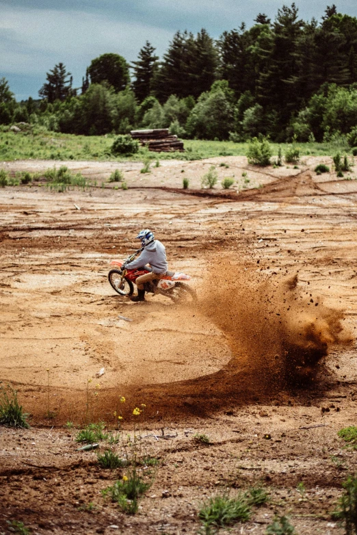 a man riding a dirt bike on top of a dirt field, pexels contest winner, process art, wet clay, crashed, summertime, minn