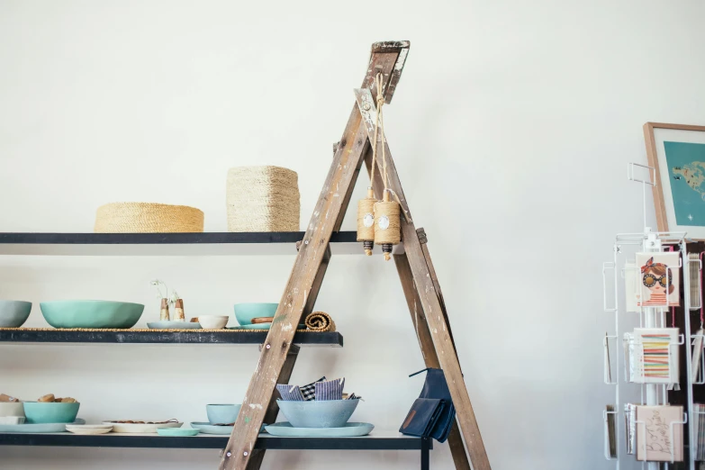 a ladder leaning against a wall in a room, a still life, unsplash, temporary art, stacking supermarket shelves, teepee, hand built ceramics, studio shot in style