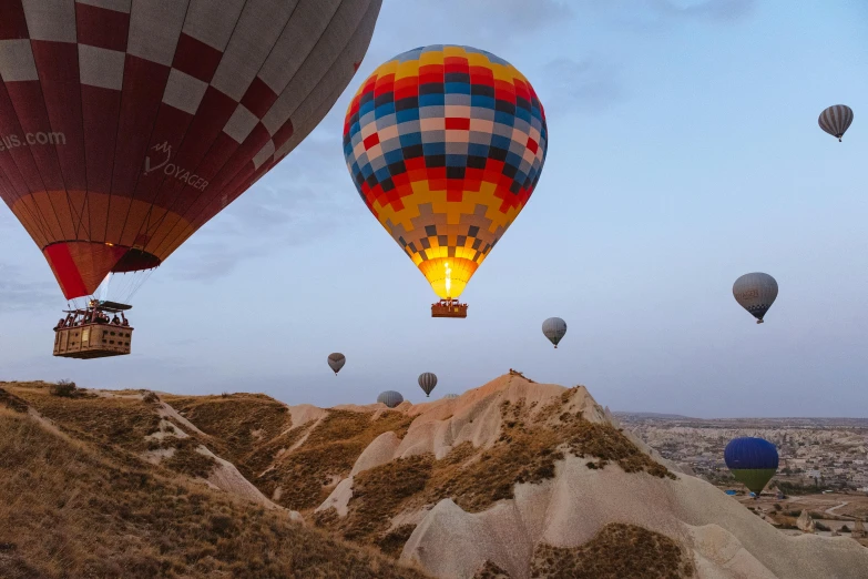 a group of hot air balloons flying in the sky, by irakli nadar, pexels contest winner, canyon, helmet is off, landing lights, slightly pixelated