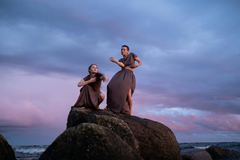 a couple of women standing on top of a rock, a portrait, inspired by Pierre Puvis de Chavannes, unsplash, happening, contemporary dance, “ iron bark, avatar image, coastal