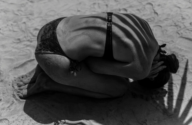 a black and white photo of a woman in a bikini on the beach, by Matija Jama, pexels contest winner, renaissance, kneeling in prayer, face down, male model, gif