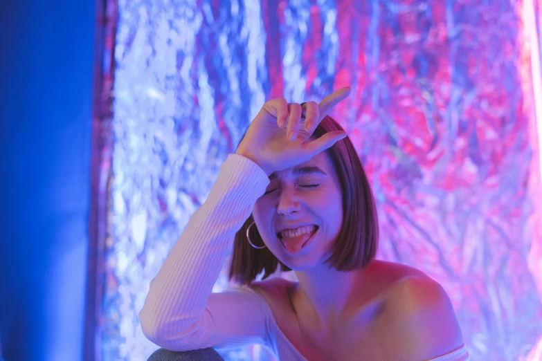 a woman that is sitting down with her hand on her head, inspired by Elsa Bleda, pexels contest winner, aestheticism, vaporwave lights, a still of a happy, charli xcx, blue and red lights