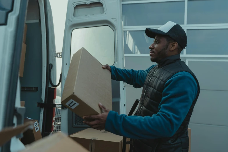 a man holding a box in front of a van, pexels contest winner, diverse, worksafe. cinematic, thumbnail, avatar image