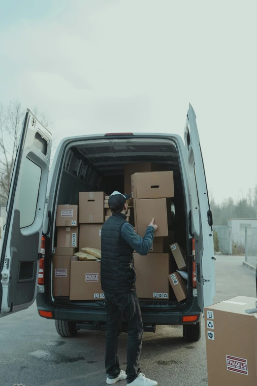 a man loading boxes into the back of a van, pexels contest winner, renaissance, curated collections, video footage, post+processing, trading depots