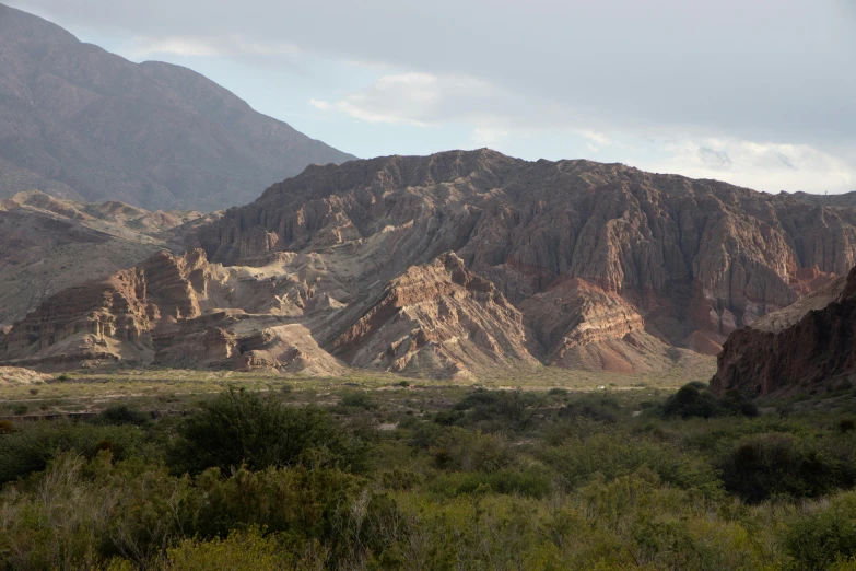 a view of a valley with mountains in the background, verdadism, reddish lava highlights, university, a monumental