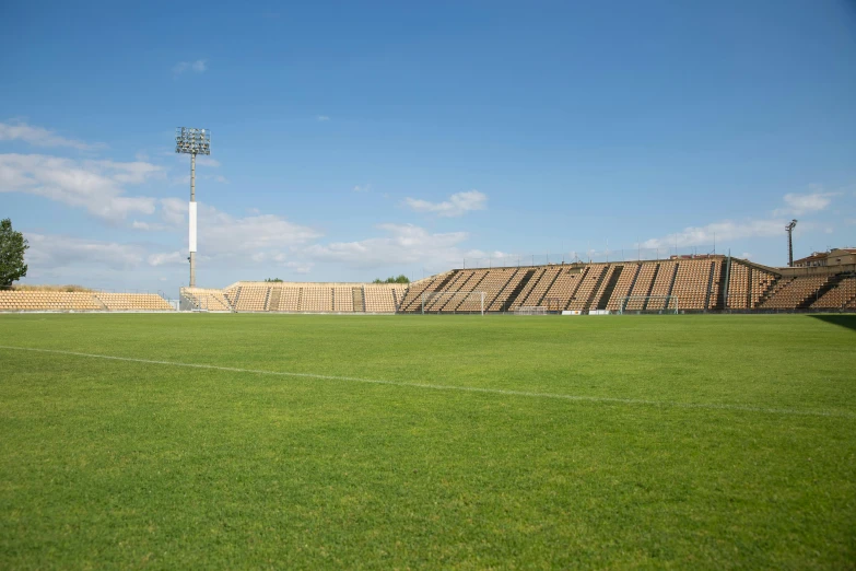 a soccer field with a stadium in the background, by Cricorps Grégoire, les nabis, pyramid surrounded with greenery, big sky, profile image, brown