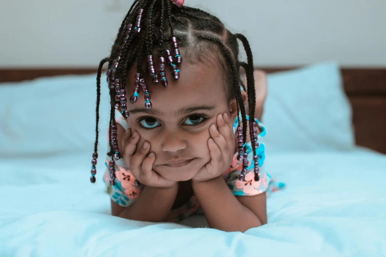 a little girl laying on top of a bed, pexels contest winner, hurufiyya, cornrows, naughty expression, ( brown skin ), illustrative!!