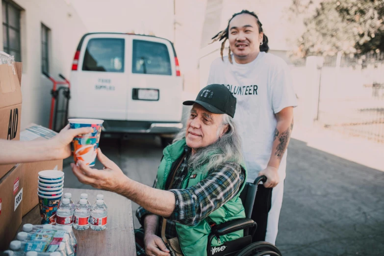 a man in a wheel chair handing a can of soda to a man in a wheelchair, a portrait, pexels contest winner, graffiti, avatar image, neil young, off - white collection, meg kimura