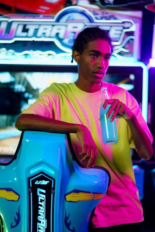 a man standing in front of a game machine, by Cosmo Alexander, featured on instagram, wearing a neon blue hoodie, holding a drink, imaan hammam, crazy racer spinning