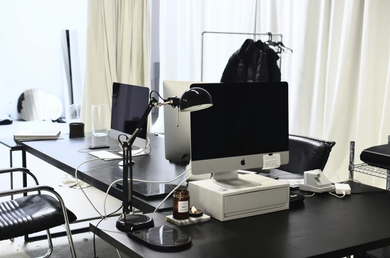 a computer sitting on top of a desk next to a chair, fashion studio, white on black, collaborative, highend