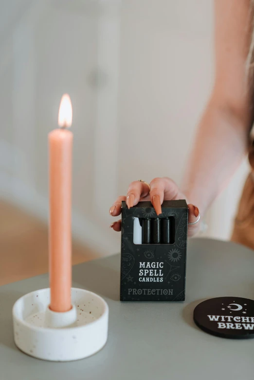 a person lighting a candle on top of a table, protection, full product shot, using magic, happy birthday